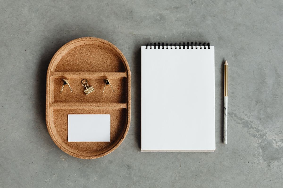 A minimalist desk organizer tray with a notebook and pen